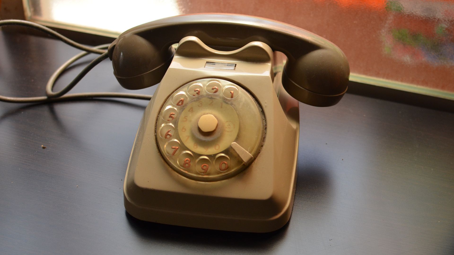 Een ouderwetse telefoon met draaischijf.