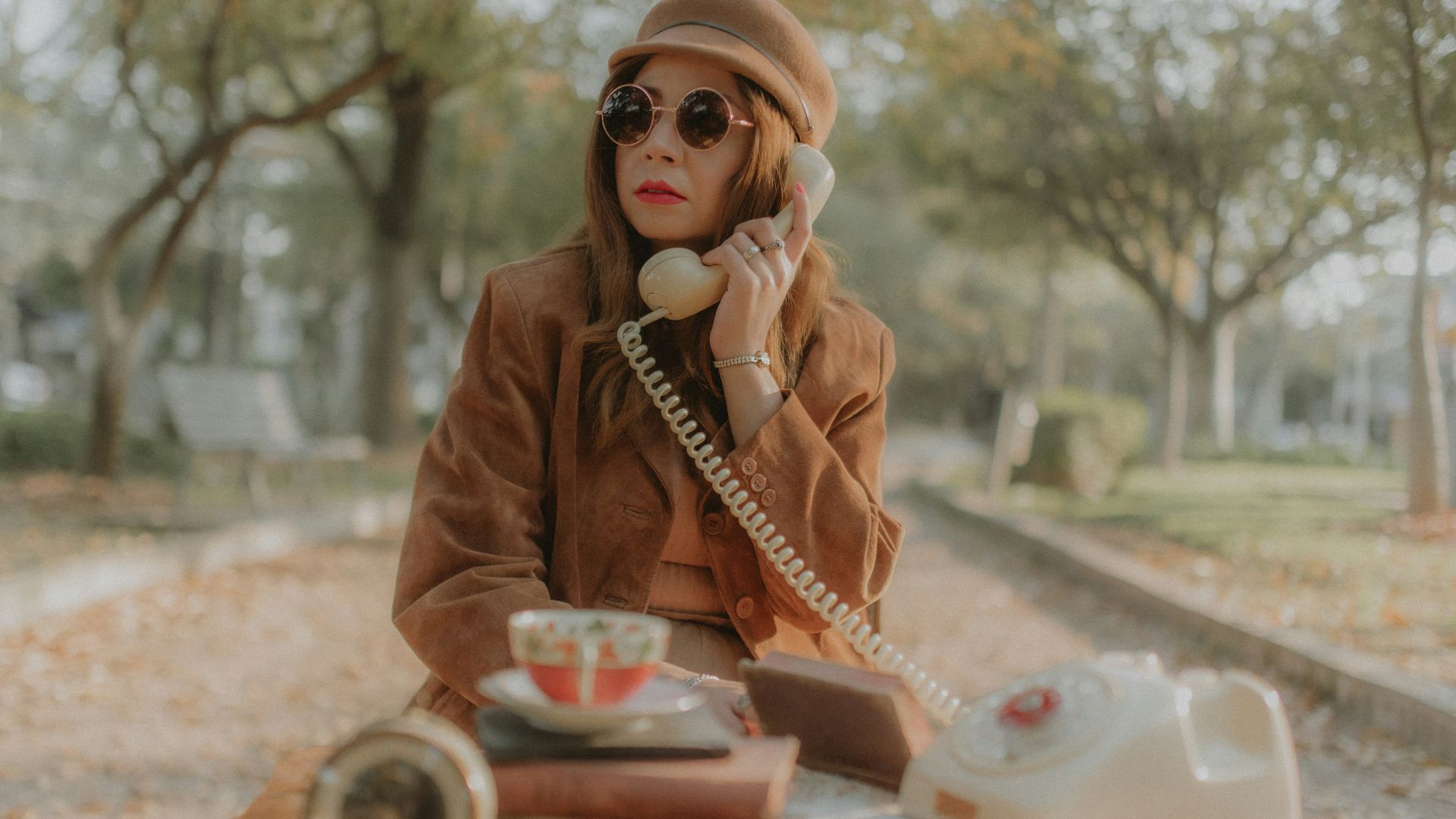 a woman sitting on the ground talking on a phone
