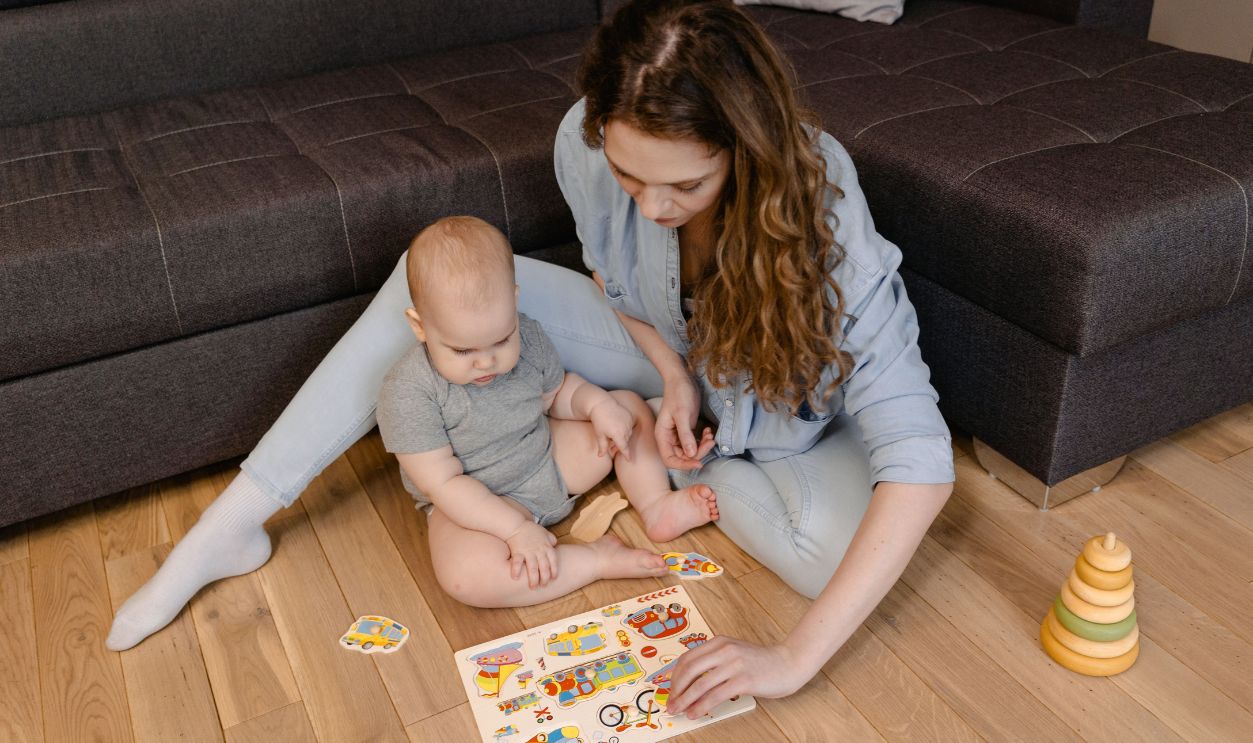 A mother and baby bonding over an educational puzzle game on the living room floor, fostering early learning.