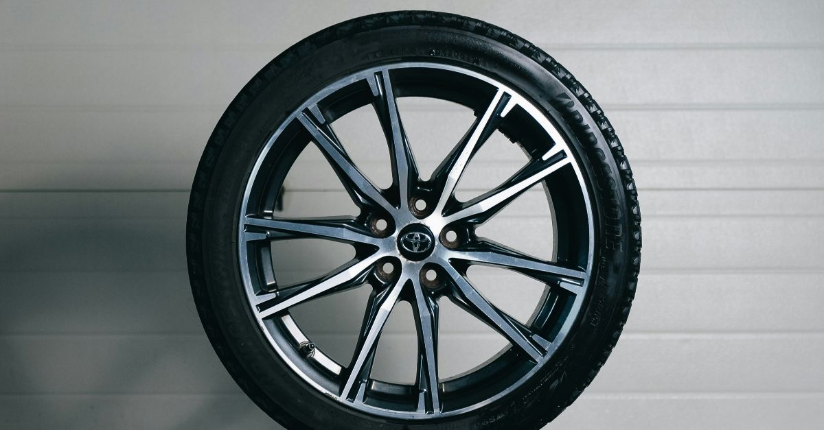 Stack of car tires with one alloy wheel on top