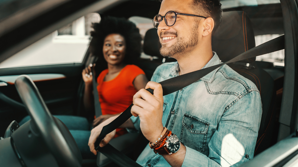 Young multiracial couple sitting in a car