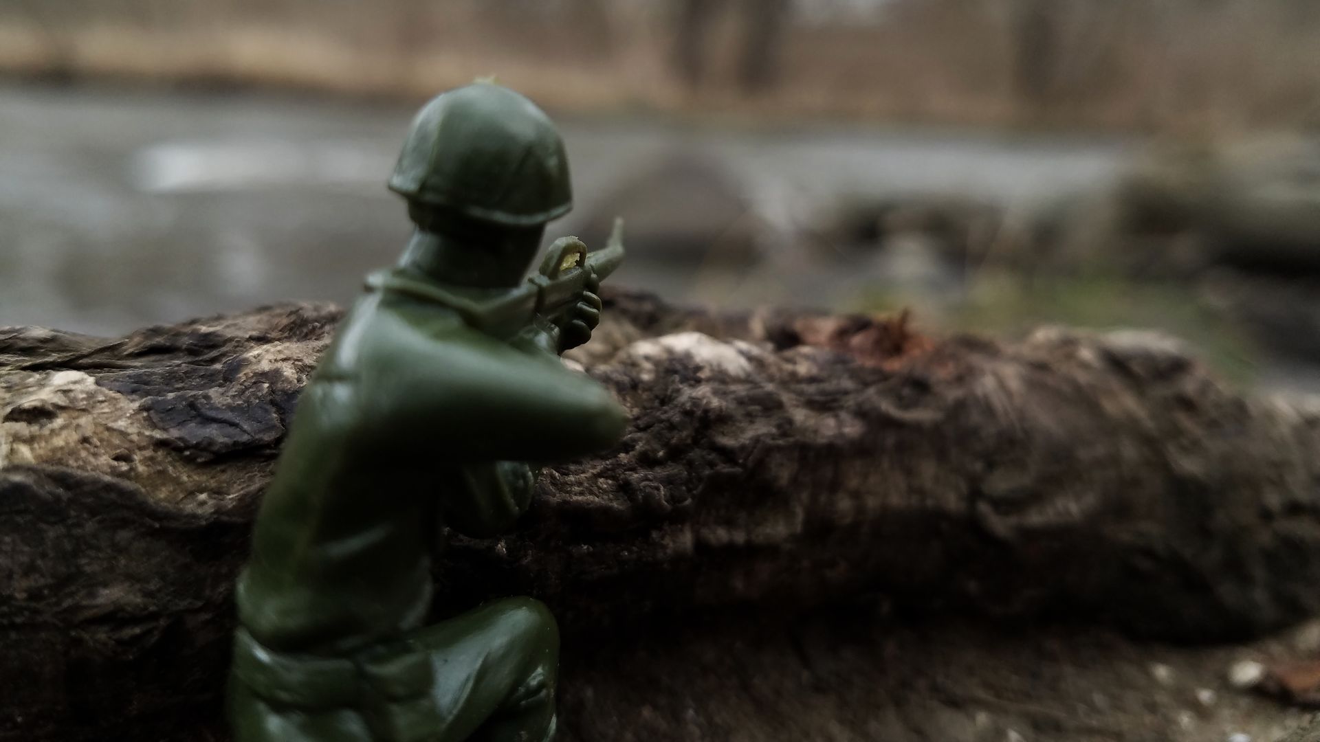 This image depicts a crouching rifleman toy soldier made of green plastic, also known as