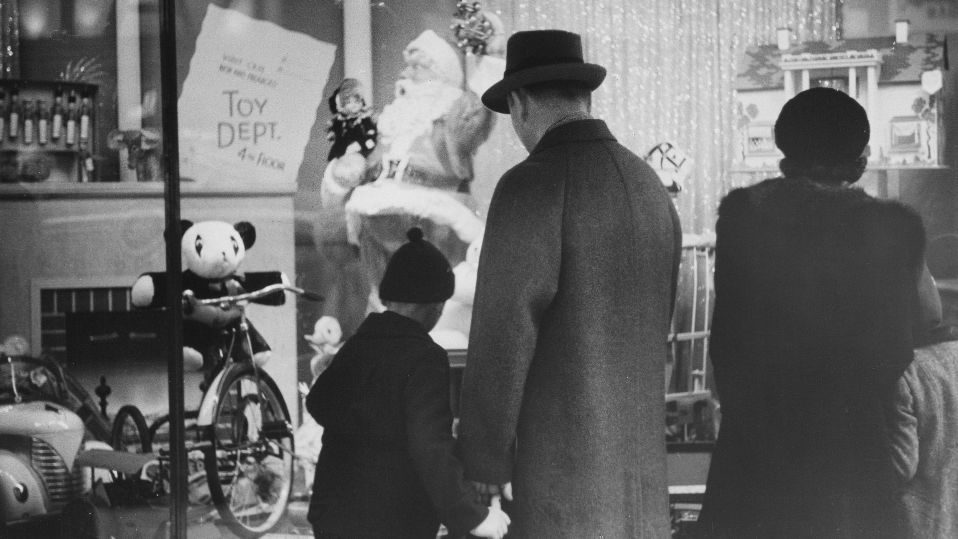 Family looking at a christmas toy store window display