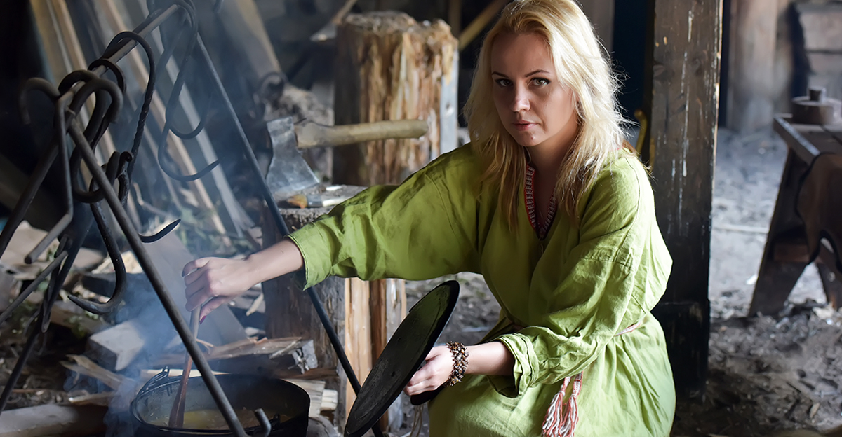 Blonde girl in vintage viking clothing prepares food in a cauldron on a fire