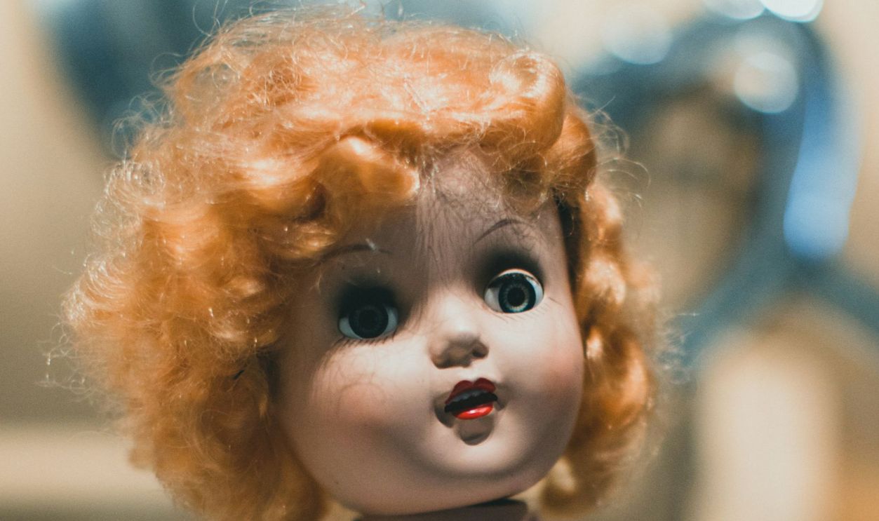 a close up of a doll with red hair