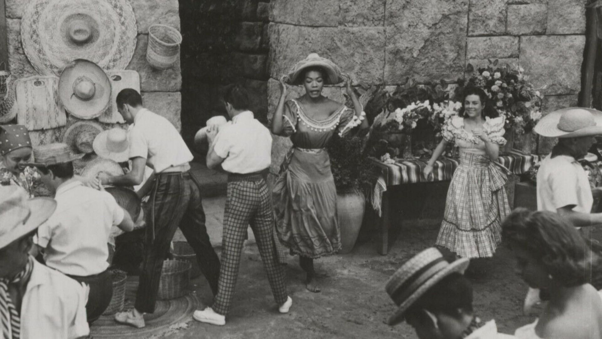 Press photo of Maya Angelou (center, wearing hat) for the 1957 film Calypso Heat Wave