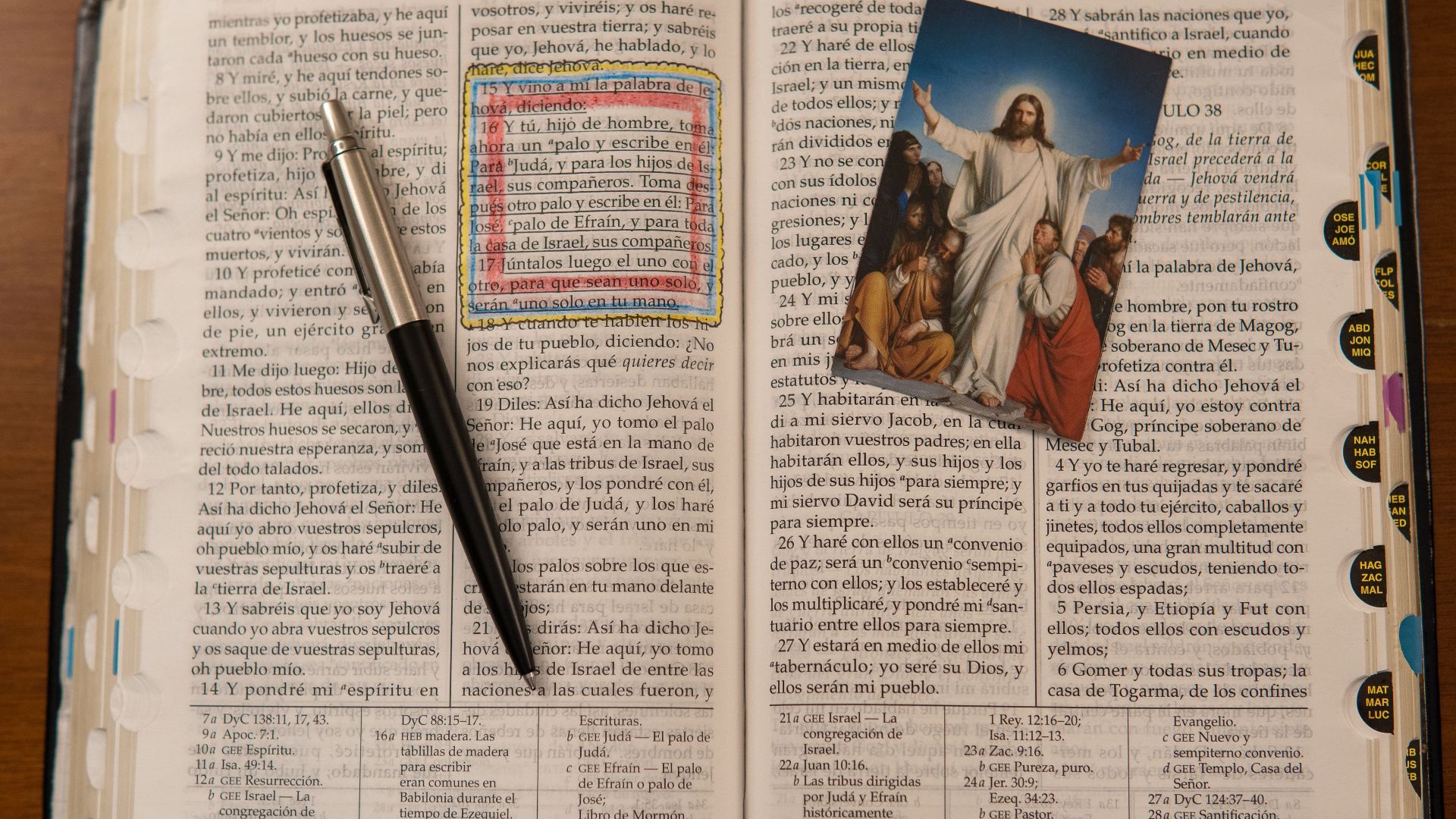 An open Bible with an image of Jesus and a pen emphasizes Christianity study.
