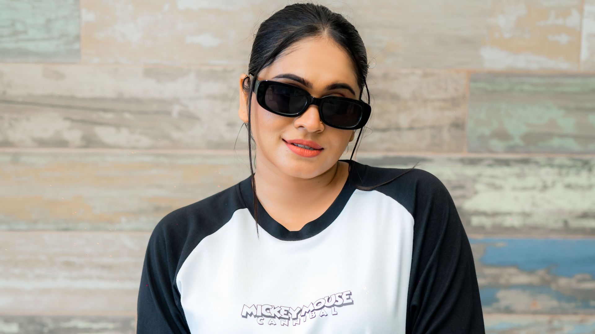 Stylish woman posing in casual streetwear with sunglasses and smart watch.