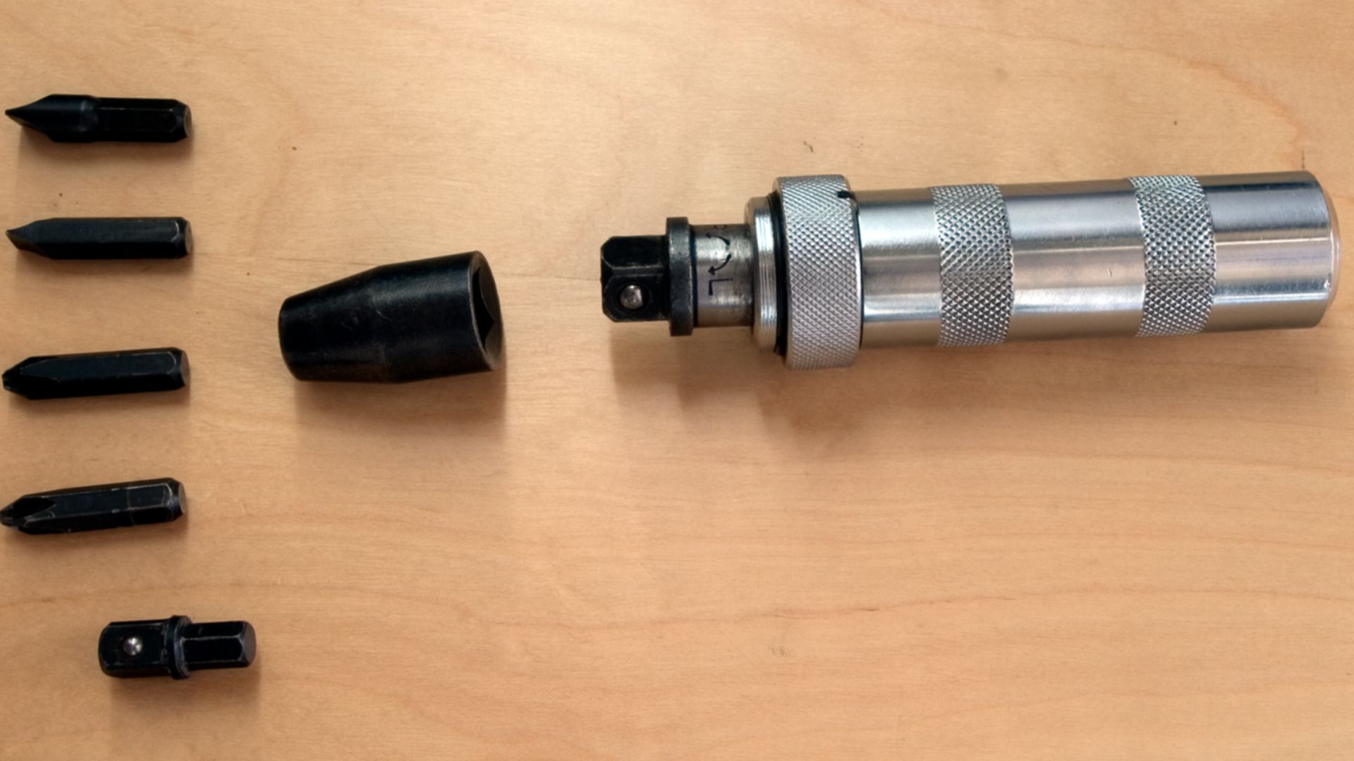 A generic impact driver with four screwdriver bits and adapters.