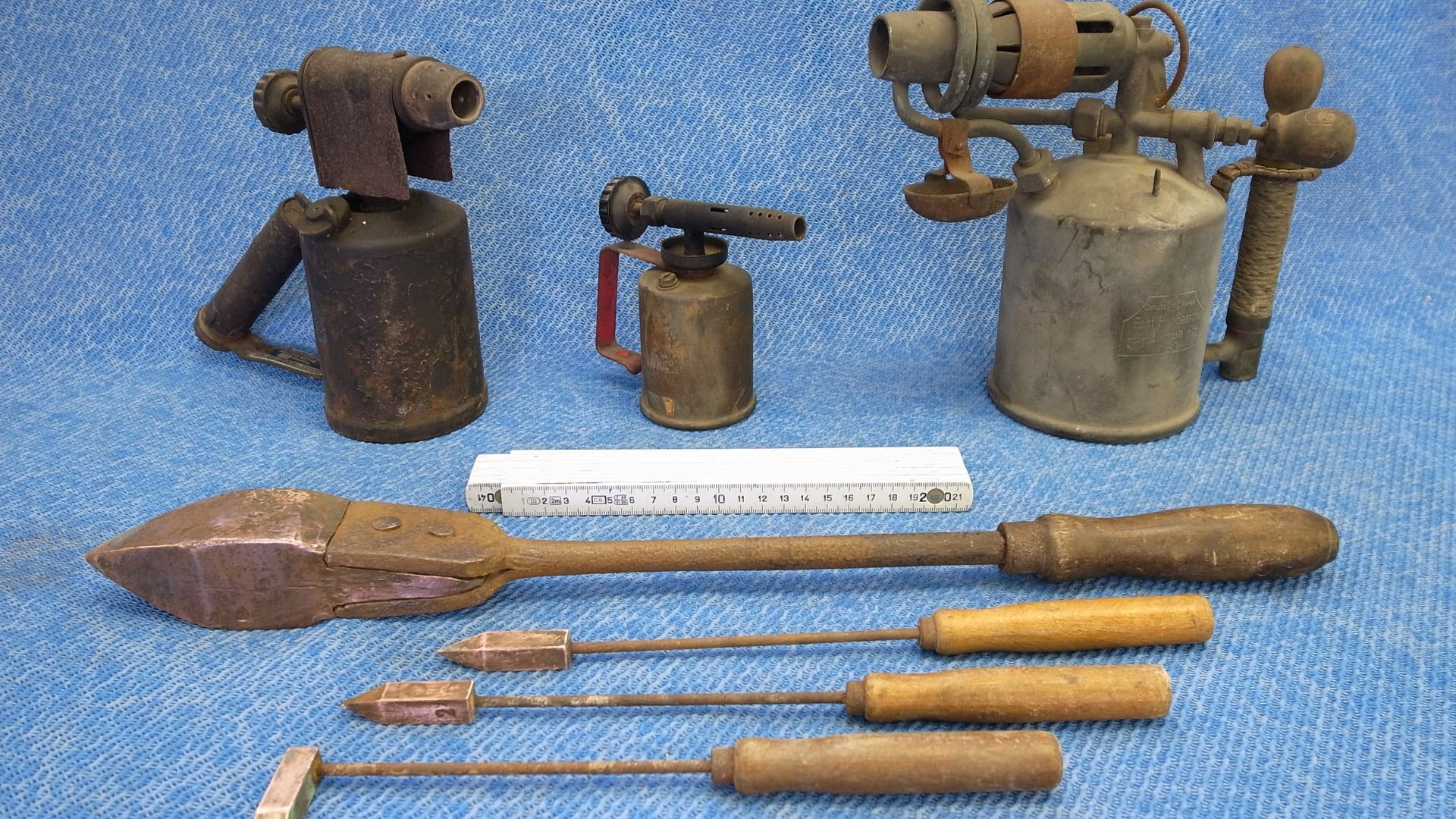 Benzinlötlampen und Lötkolben,Beschreibung: (v.l.n.r, v.o.n.u.) Benzingasoline vom VEB Sturmlaternenwerk Beierfeld, kleine Benzinlötlampe von Vulcano Alemania, Echt Hänelsche Lampe No. 30, Kupferlötkolben Spitzform, 3 Stück Dilettanten-Lötkolben Spitz- u