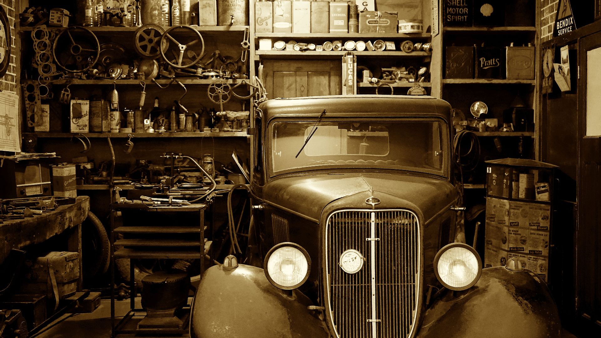 A vintage car surrounded by antique tools and parts in a nostalgic workshop.