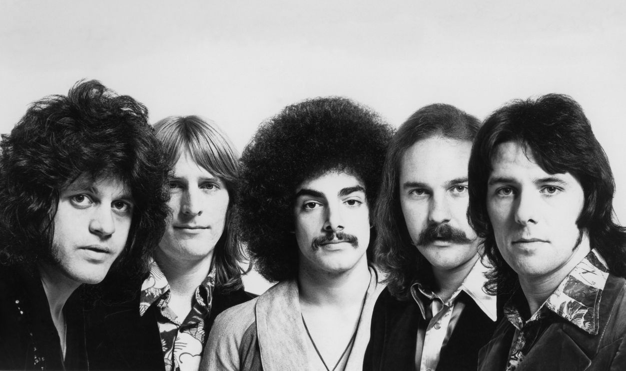 Getty Images - 74278952 - Rock group Journey (l-R Gregg Rolie, Ross Valory, Neal Schon, George Tickner and Aynsley Dunbar pose for a CBS Photo circa 1975.