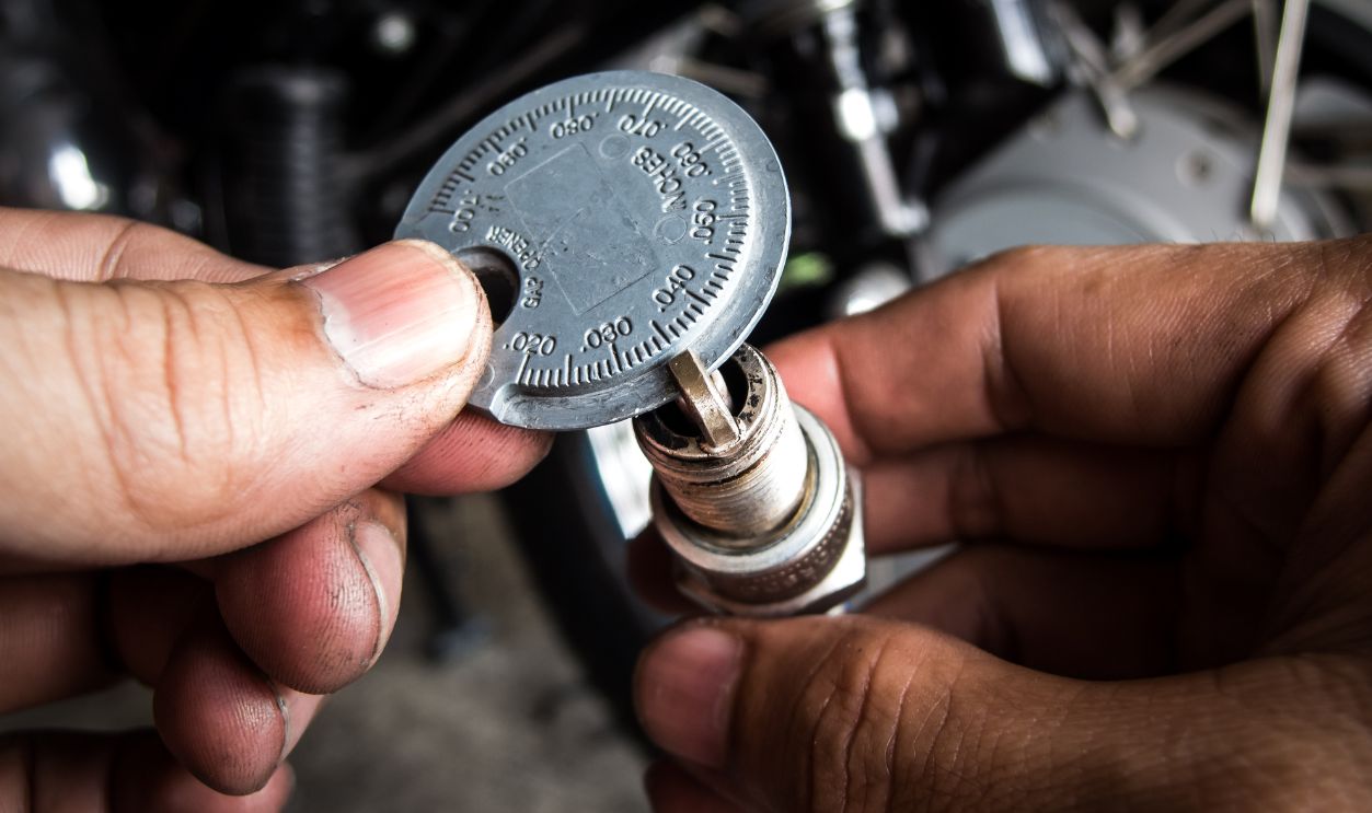 Shutterstock - 1906885366 - Mechanic is measuring spark plug gap.