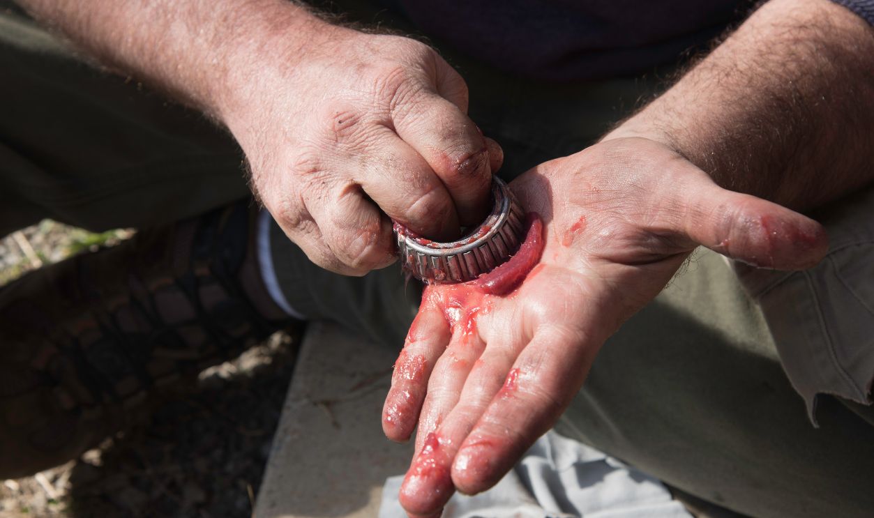 Shutterstock - 2145579465 - Male hands packing grease into a wheel bearing.