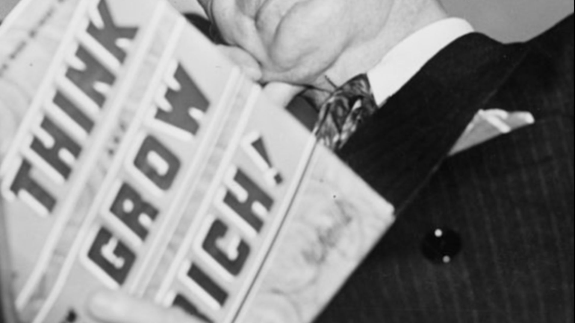American self-help writer Napoleon Hill (1883-1970) holding his book,