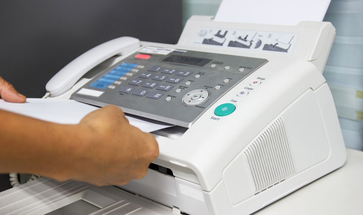 hand man are using a fax machine in the office. Business concept 
