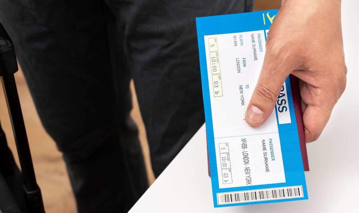 Unrecognizable person holding up a airline boarding pass at home