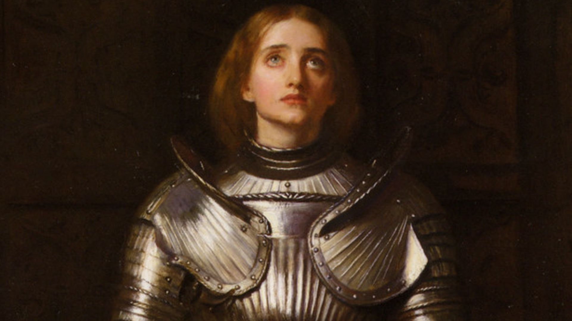 Oil painting, on canvas, of Joan of Arc wearing a suit of armor over a red skirt. Painted by John Everett Millais and published in 1865.