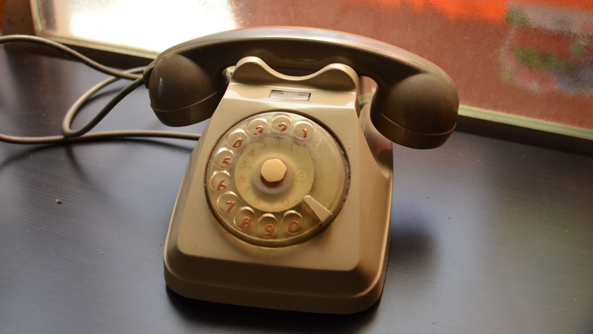 Een ouderwetse telefoon met draaischijf.