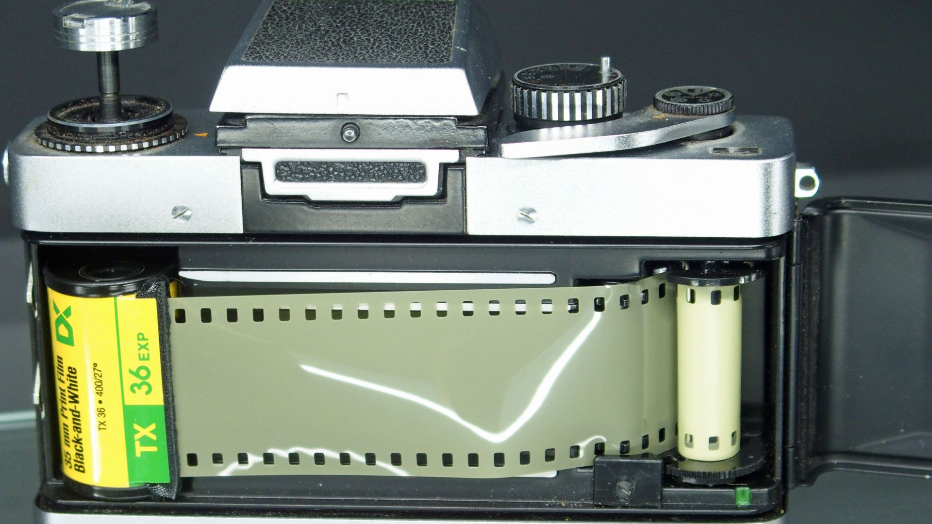 A roll of 135 film loaded into a camera, film door opened.