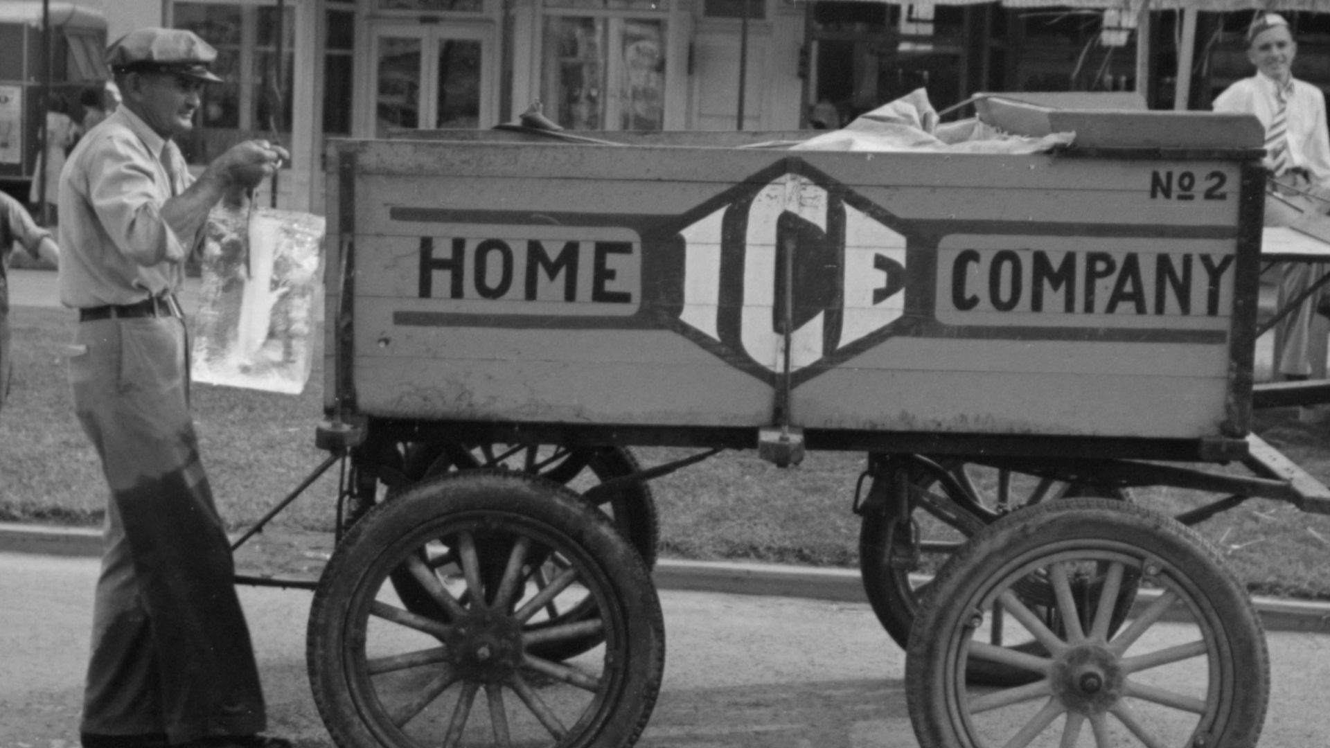 Delivering ice to stands, National Rice Festival, Crowley Louisiana, 1938. Shows iceman holding block of ice in tongs behind horse drawn ice wagon.