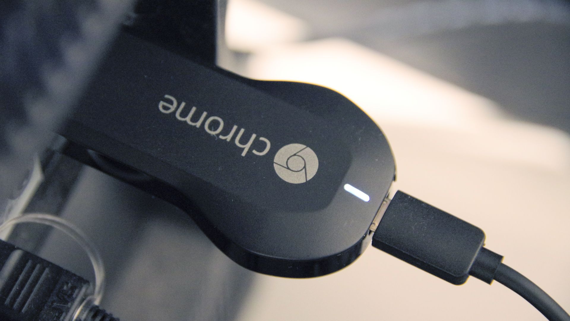 An image of Google's Chromecast device plugged into the HDMI port of a television