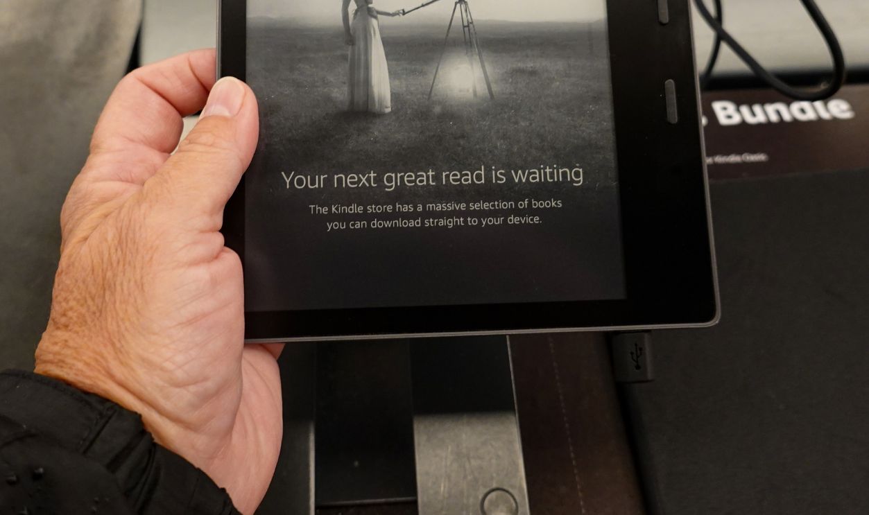Seattle, WA/USA-6/15/19: A person holding an  Amazon Kindle Oasis device that is on sale at an Amazon Book Store.