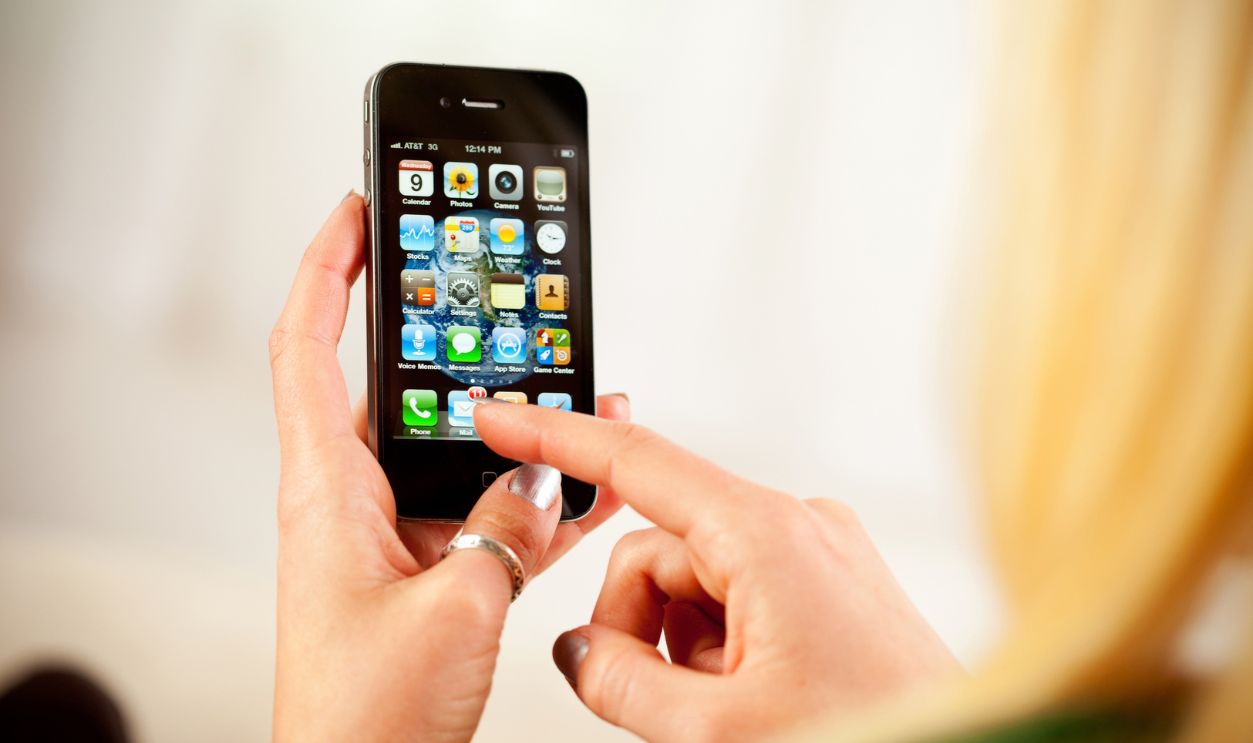 St. Louis, Missouri, USA - March 9, 2011: Woman Accessing Home Screen On Apple iPhone 4