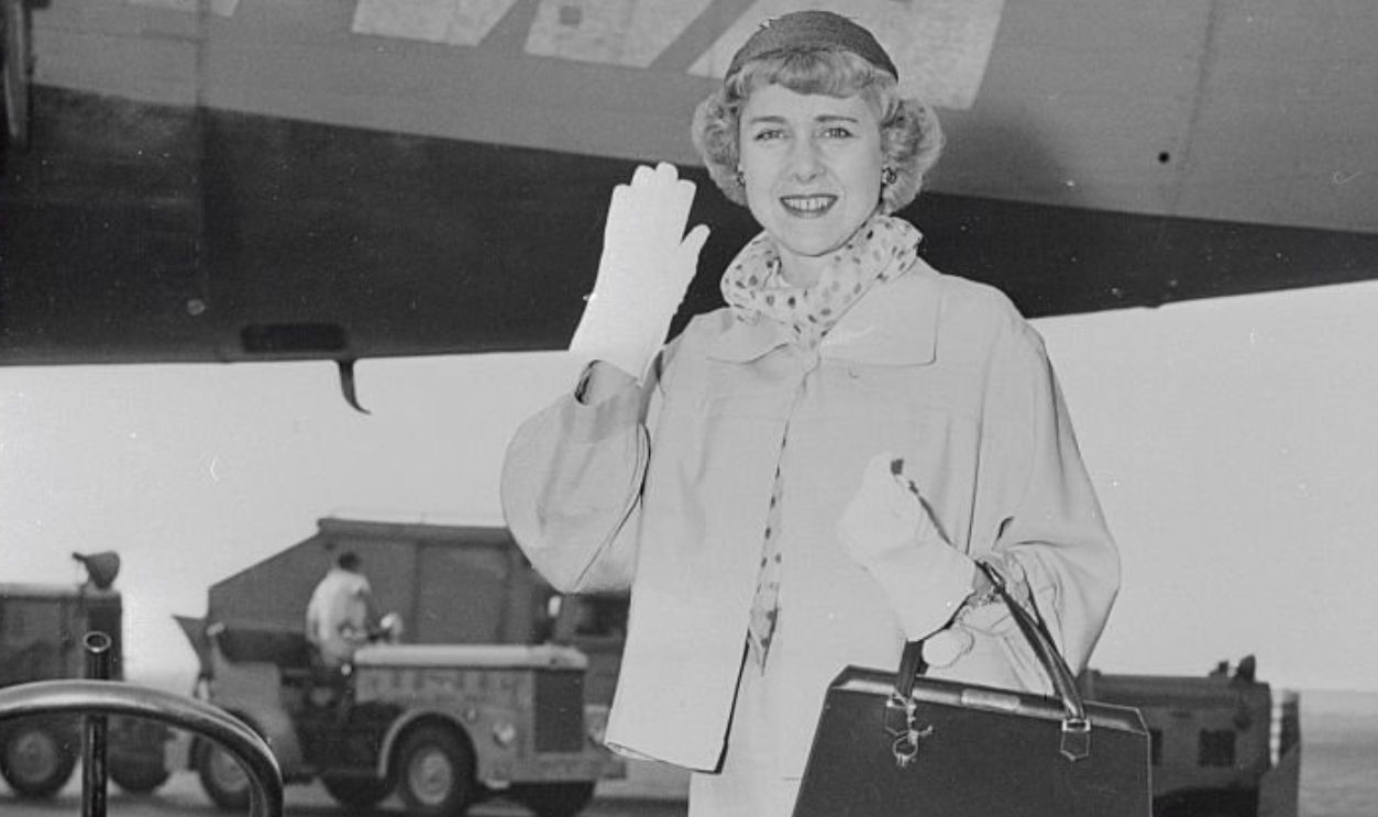 (Original Caption) Mrs. Clare Boothe Luce, U.S. Ambassador to Italy, waves a greeting after arriving from Rome via TWA for a three week vacation. Mrs. Luce will spend part of her holiday at her Connecticut home before reporting to Washington for State Department consultations.
