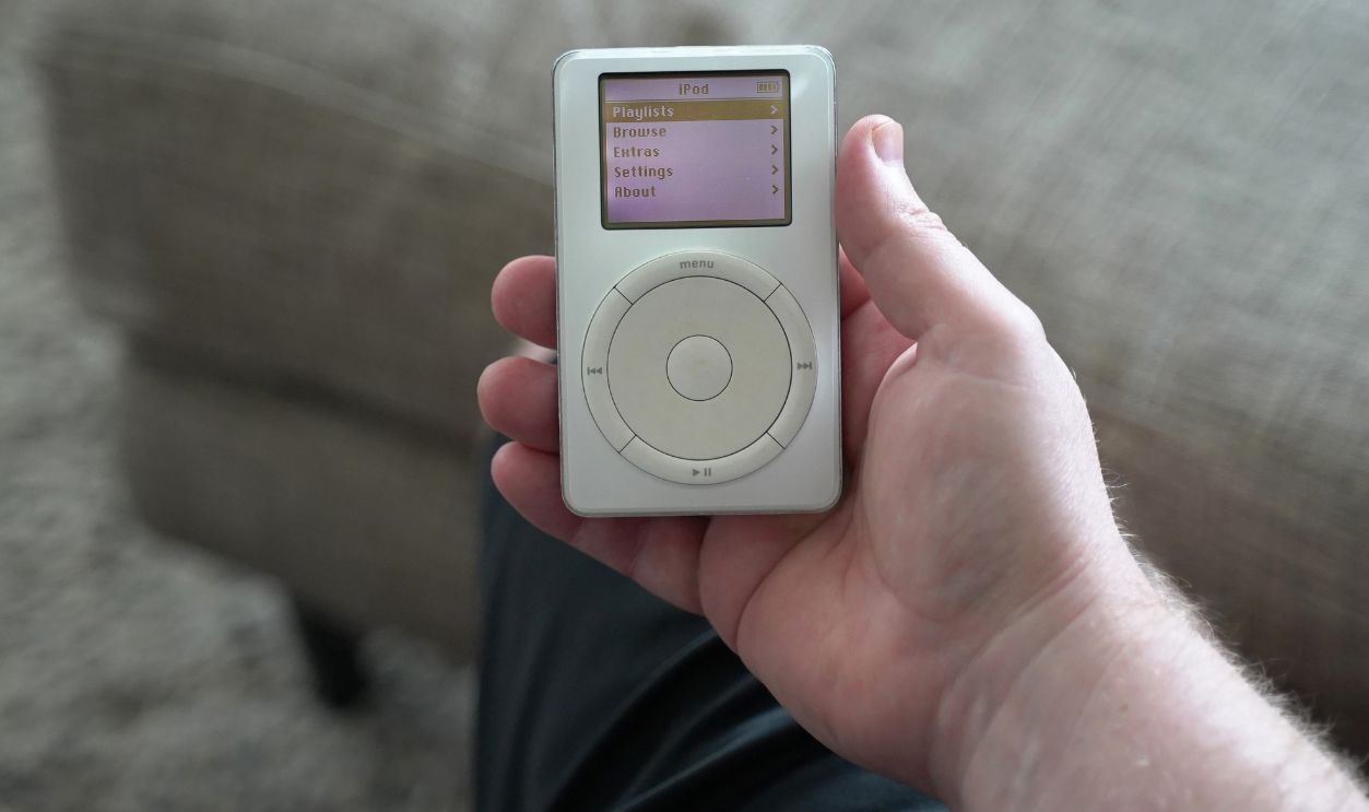 A male hand holding a 1st generation iPod with the main display turned on. Originally released October 2001. January 21, 2021. San Francisco, CA.