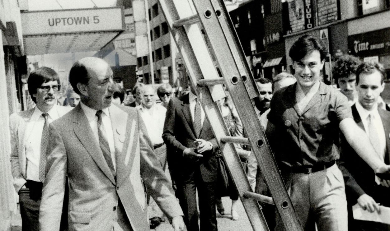 Getty Images - 502325909 - Walking under a ladder on Yonge St. didn't appear to strike Finance Minister Marc Lalonde with premonitions of electoral disaster today as he indulged in a little main-street electioneering with colleague Jim Coutts; Liberal candidate in Spadina riding. Coutts steered a more prudent course.