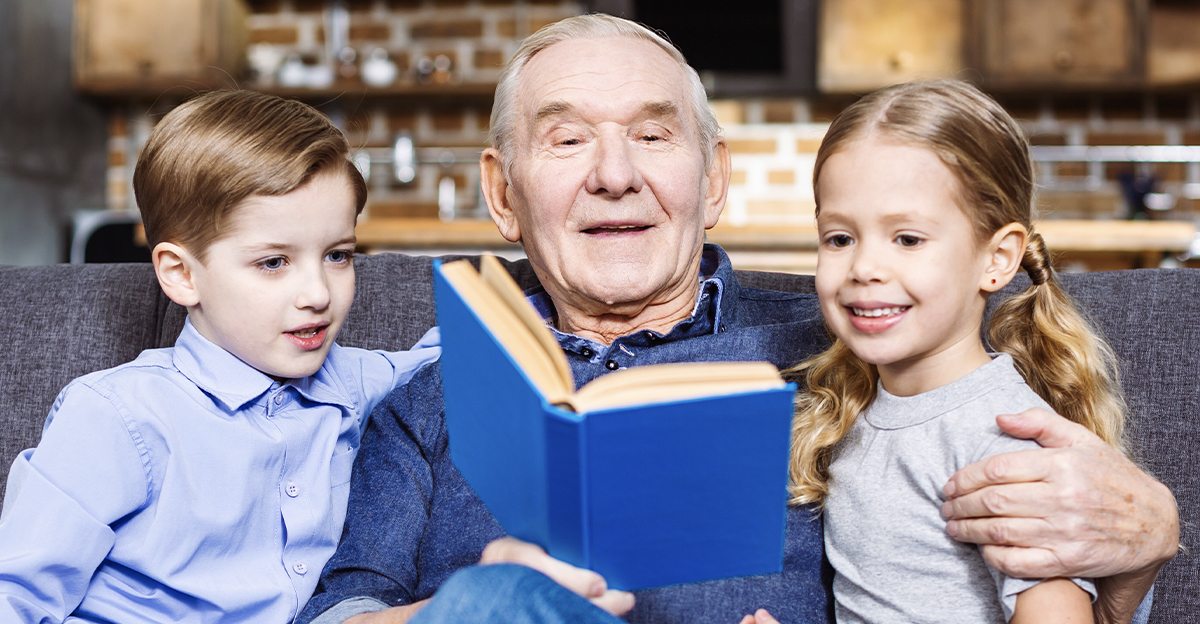 Positive retired man reading a book for his grandchildren