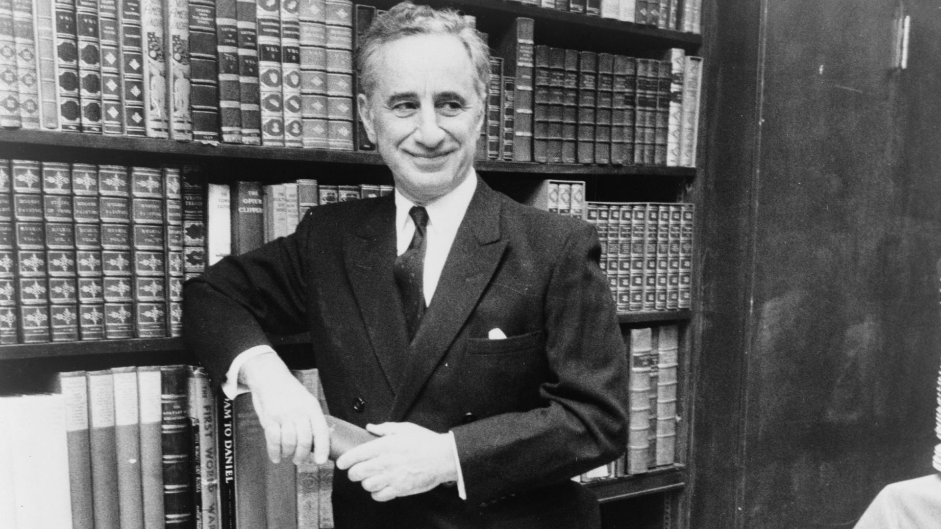 Elia Kazan, full-length portrait, standing before bookshelves at Brentano's book store / World Journal Tribune photo by James Kavallines.