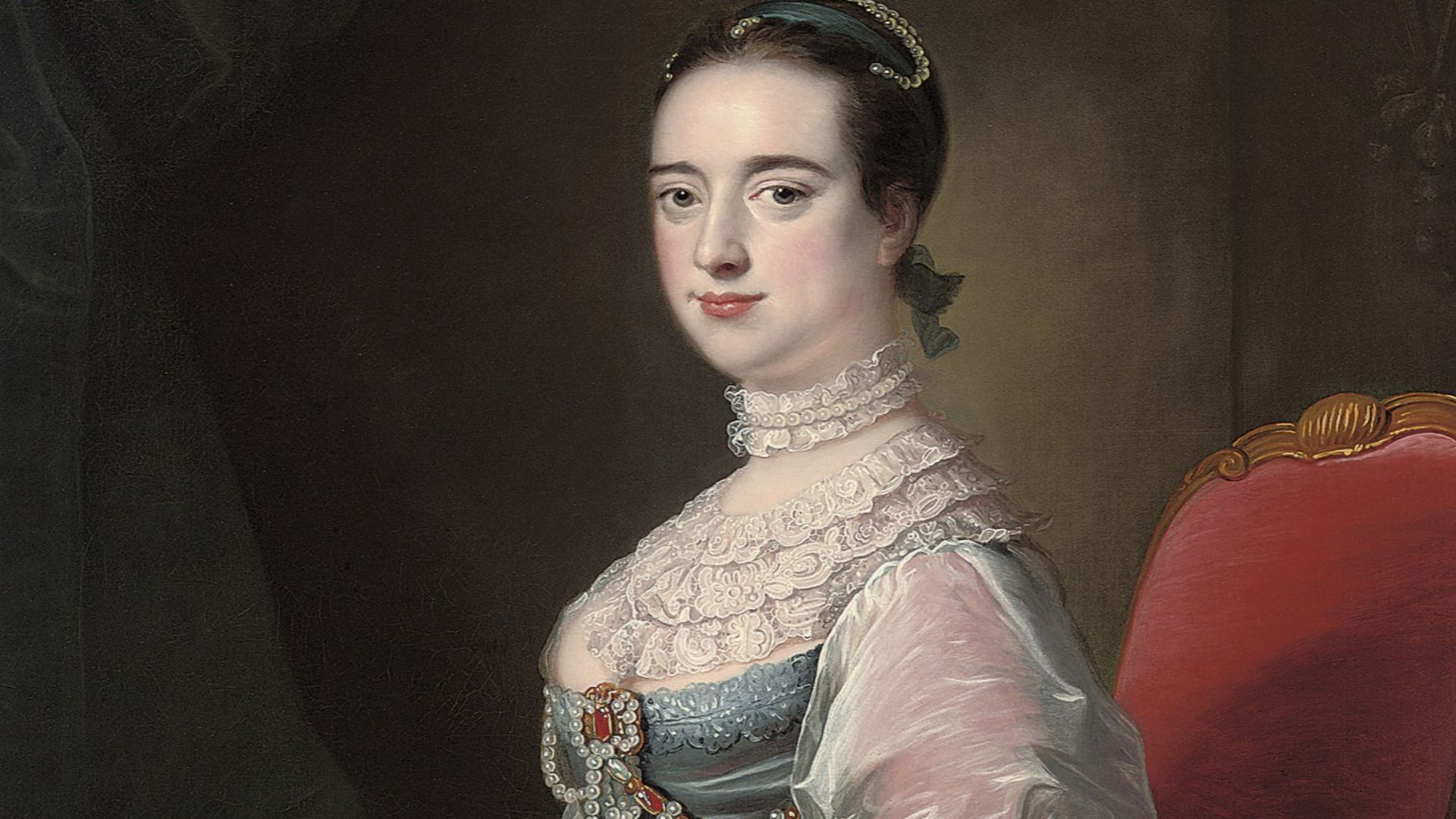 Portrait of a lady, three-quarter-length, seated in a blue satin jewelled dress with lace sleeves and collar, with a pug dog