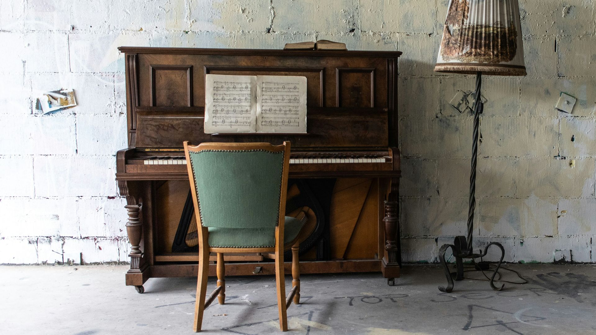brown upright piano beside gray floor lamp