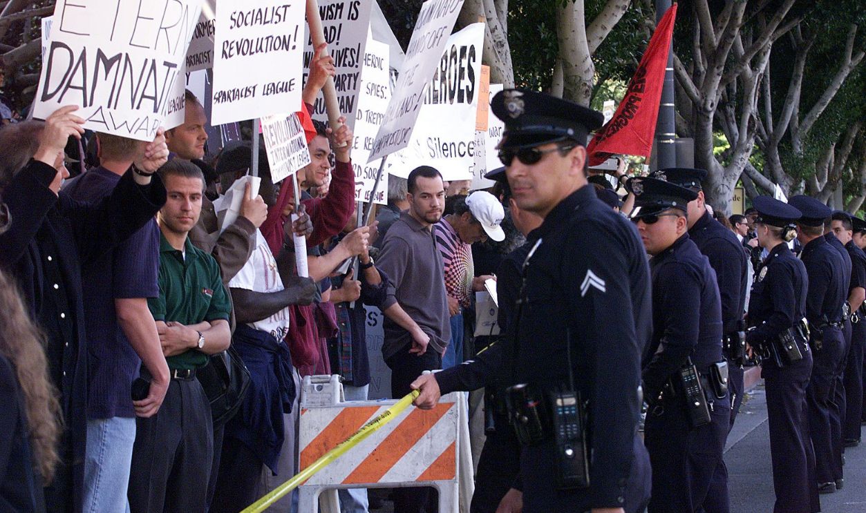 LOS ANGELES, UNITED STATES: Police are positioned before demonstrators 21 March 1999 in Los Angeles during a protest against the Lifetime Achievement Award to be presented to US film director Elia Kazan at the 71st Annual Academy Awards. The award to Kazan, who directed "On the Waterfront", has angered many stars who recall how he destroyed careers when he "named names" before the US House Un-American Activities Committee's infamous 1950's probe of communists in Hollywood.