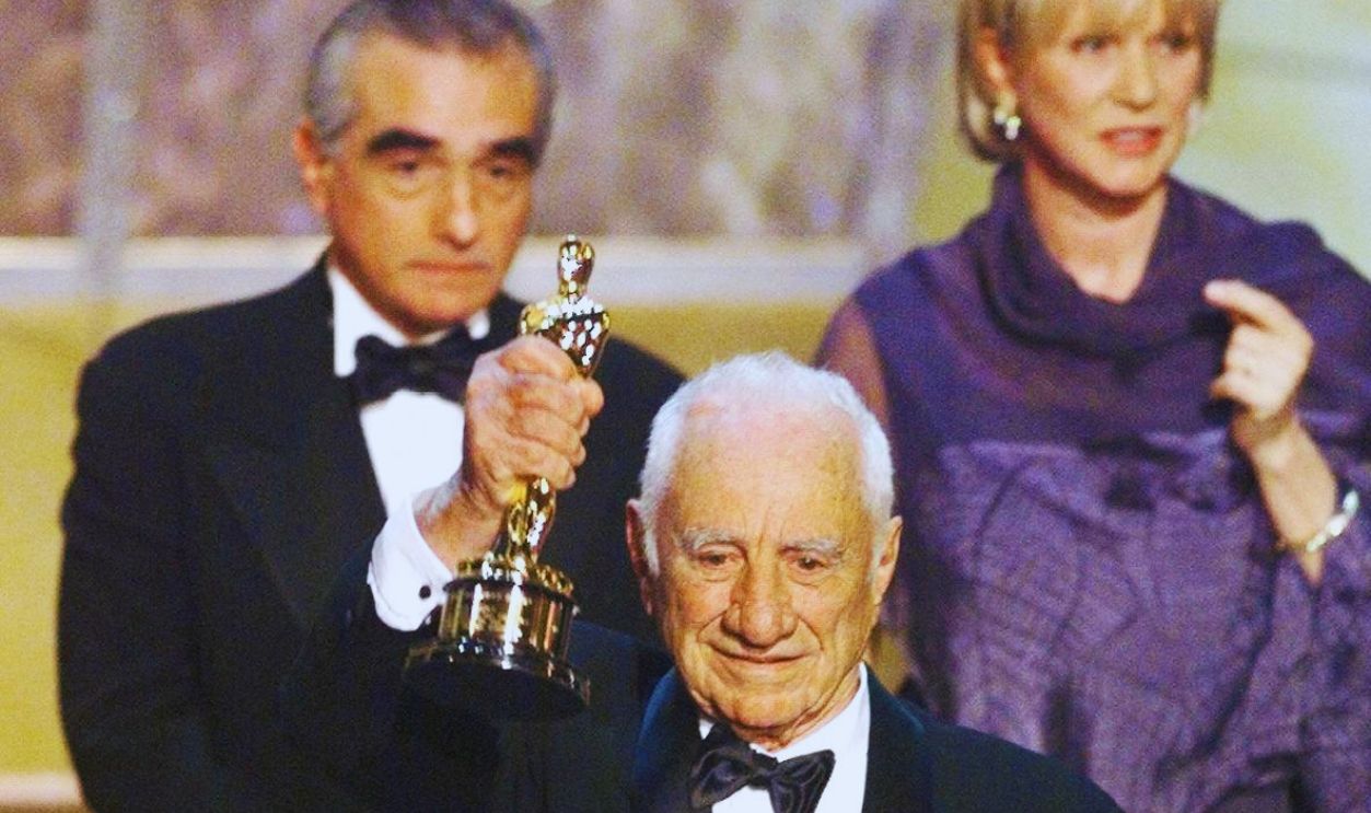 Director Elia Kazan holds up his Honorary Oscar during the 71st Academy Awards 21 March 1999 at the Dorothy Chandler Pavilion in Los Angeles. Behind him are presenter-director Martin Scorsese and Kazan's daughter Lanie.