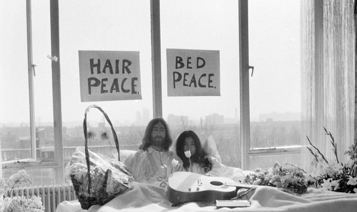 John Lennon and his wife Yoko Ono are having a weeks love-in their room at the Hilton Hotel, Amsterdam. They will stay in bed for seven days - with fruit, flowers and peace signs. March 1969 Z02902-001