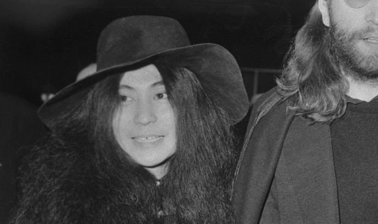 (Original Caption) The peace pilgrims...Those dedicated advocates of peace, John and Yoko Lennon, walk hand-in-hand at London's Heathrow Airport en route to Canada.