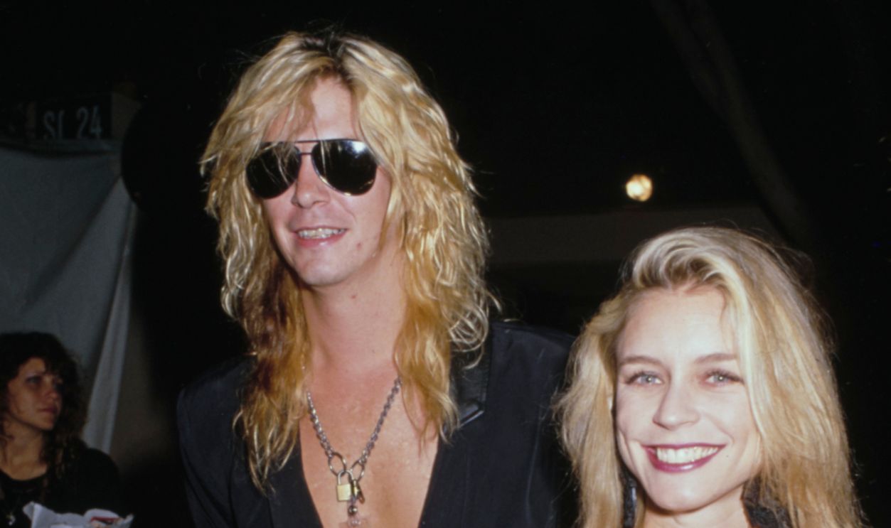 American guitarist and songwriter Duff McKagan and his partner, Mandy Brixx, wearing a black bra top, attend the 1989 MTV Video Music Awards, held at the Universal Amphitheatre in Los Angeles, California, 6th September 1989.