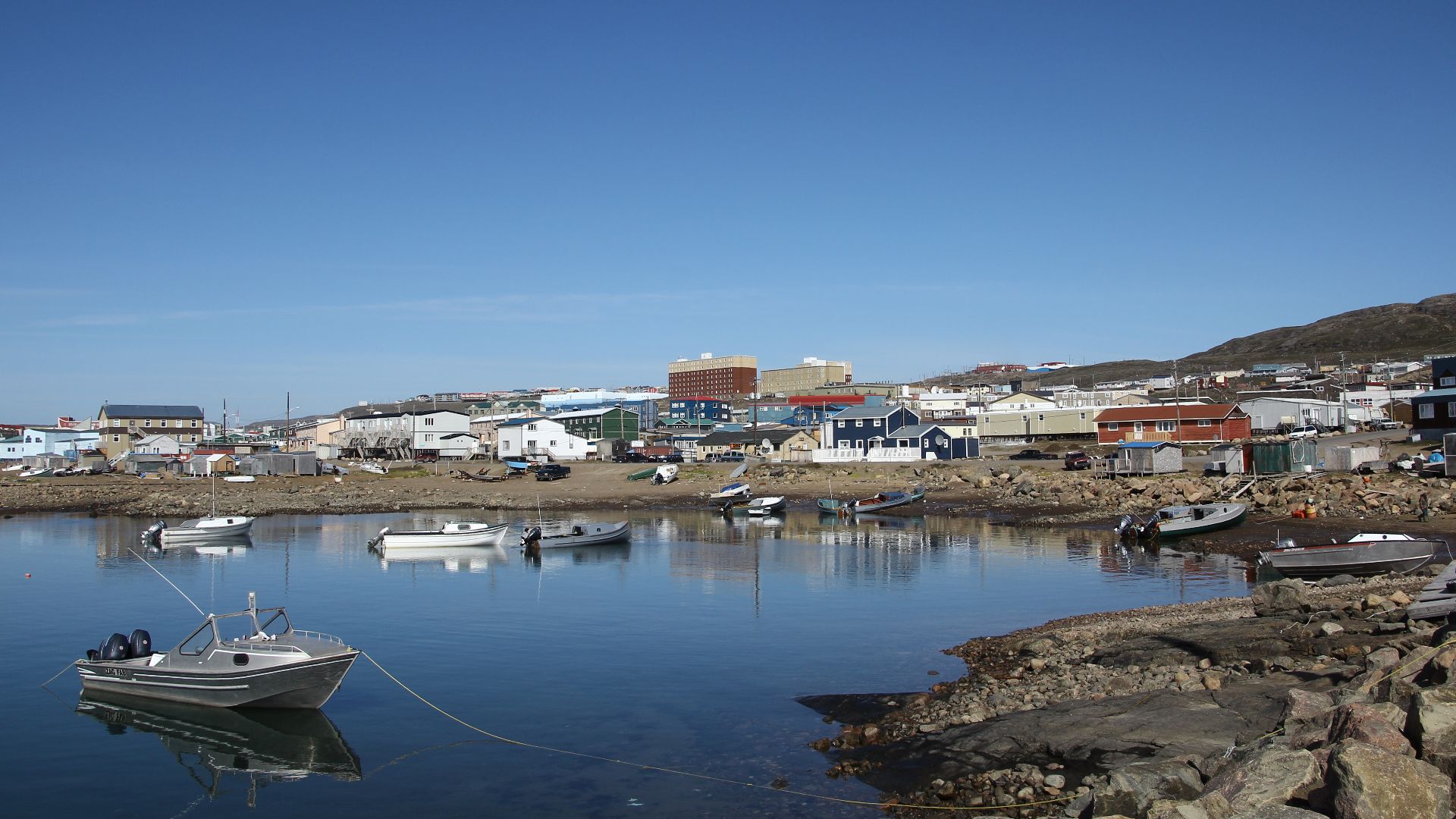 Waterfront of Iqaluit with fisher boats in the foreground and the cityscape of the town in the background