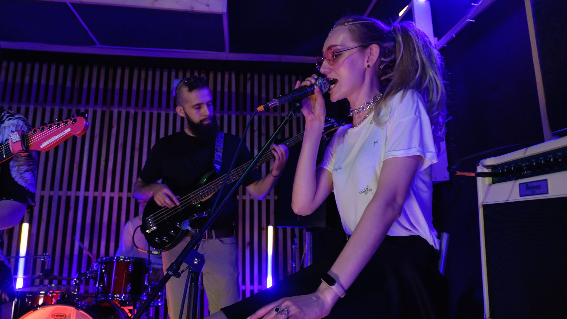 Dynamic live performance of a band with vibrant lighting and engaging musicians.