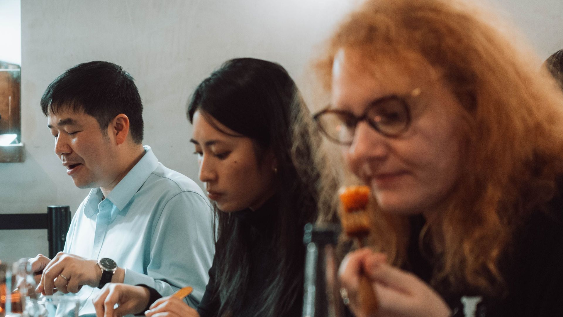 A diverse group of adults enjoying a meal together in a cozy indoor restaurant setting.