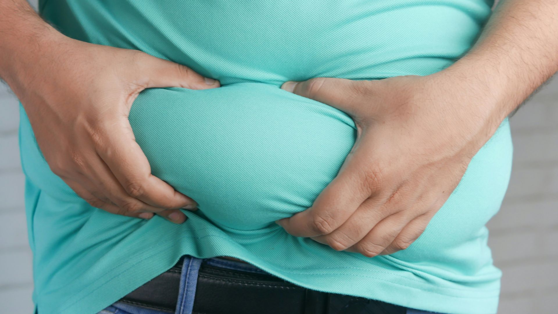 a man holding his stomach with his hands