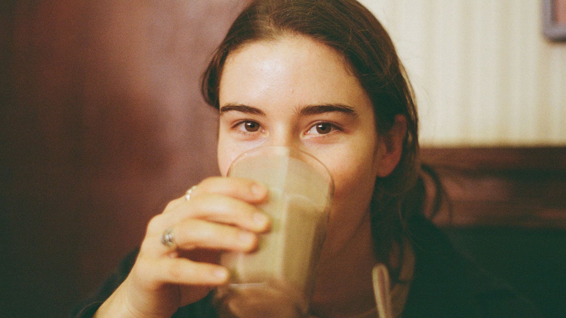 Young woman drinking a milkshake at a diner