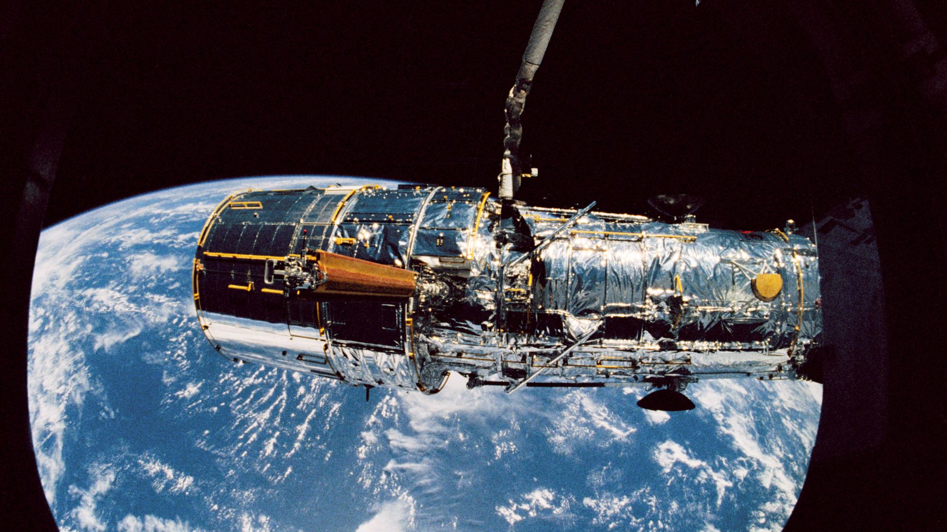 STS031-10-035 - Held in appendage deploy position by Discovery's, Orbiter Vehicle (OV) 103's, remote manipulator system (RMS), the Hubble Space Telescope's (HST's) starboard solar array (SA) bistem cassette is released from its stowed position on the Supp
