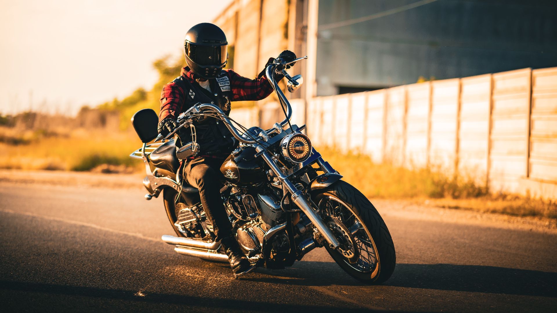 Biker rides a cruiser motorcycle on an open road during sunset, showcasing adventure and freedom.
