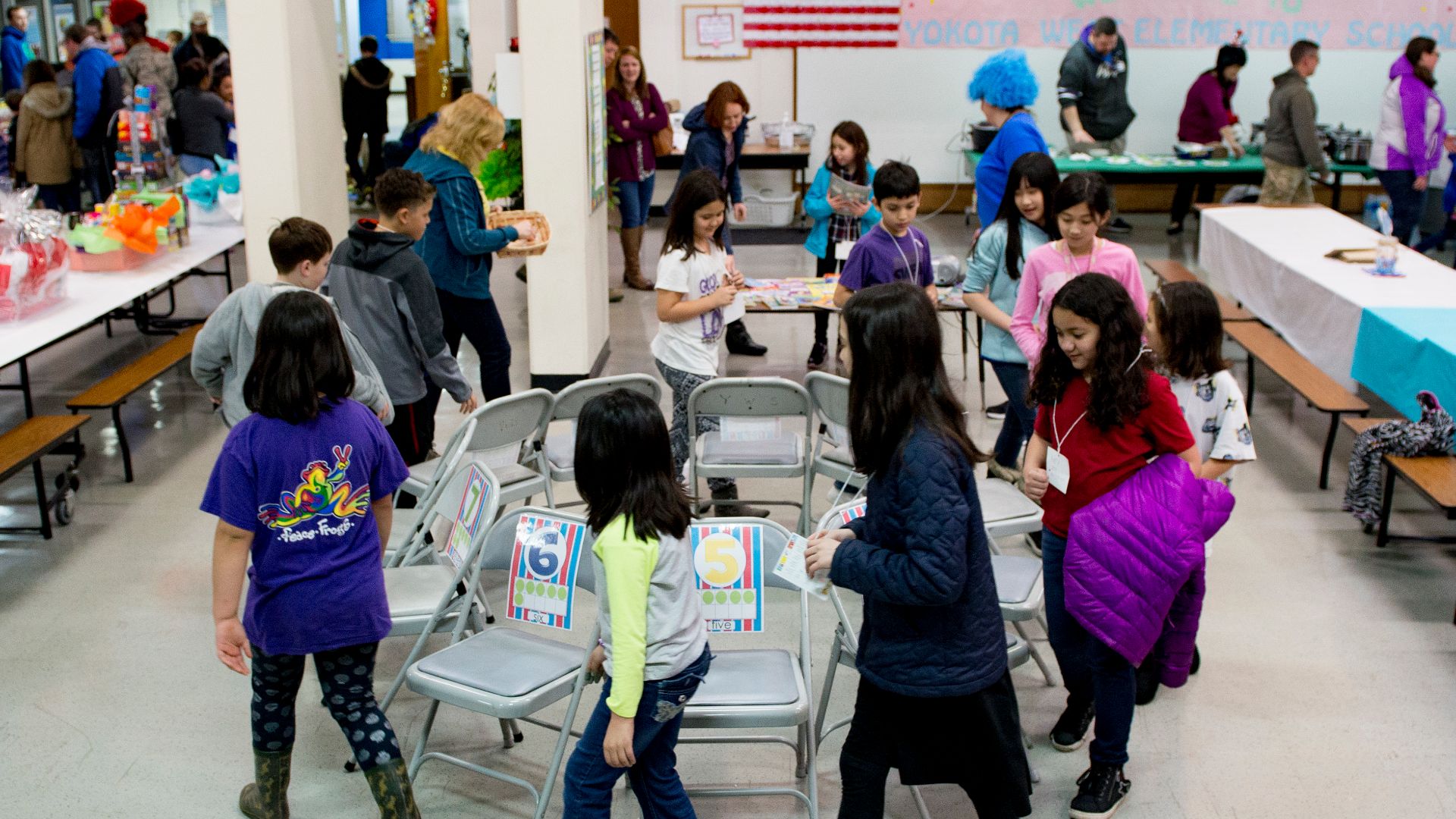 Children play the game Musical Chairs to win books at West Elementary School during a National Read Across America Day event, Mar. 2, 2017 at Yokota Air Base, Japan. The Dr. Seuss Family Night event at West Elementary School included various activities de