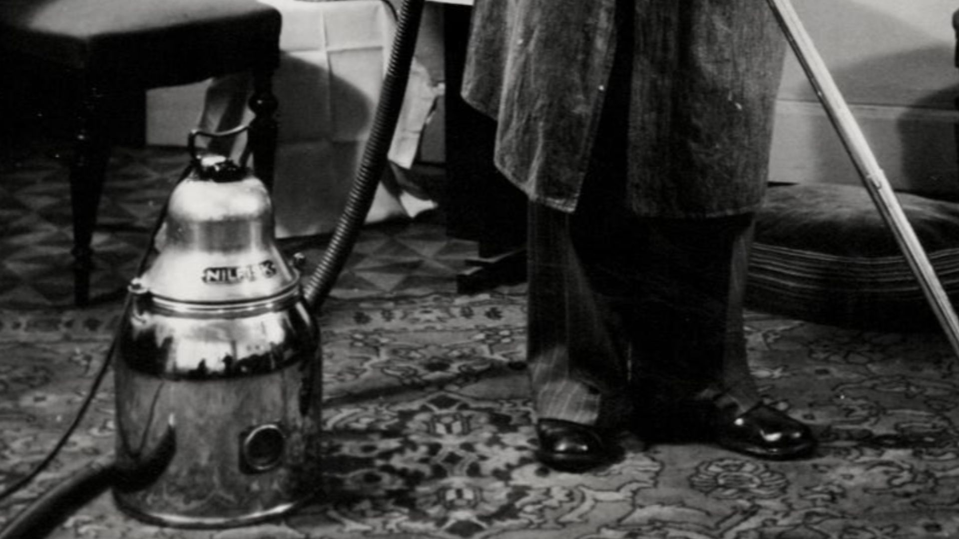 Nationaal Archief / Spaarnestad Photo, SFA006004681
Man in stofjas stofzuigt Perzisch tapijt in de huiskamer met Nilfisk-stofzuiger. Opname uit een fotoroman. Nederland, 1950-1960.
Man cleaning a Persian carpet with a Nilfisk vacuum cleaner. The Netherlan