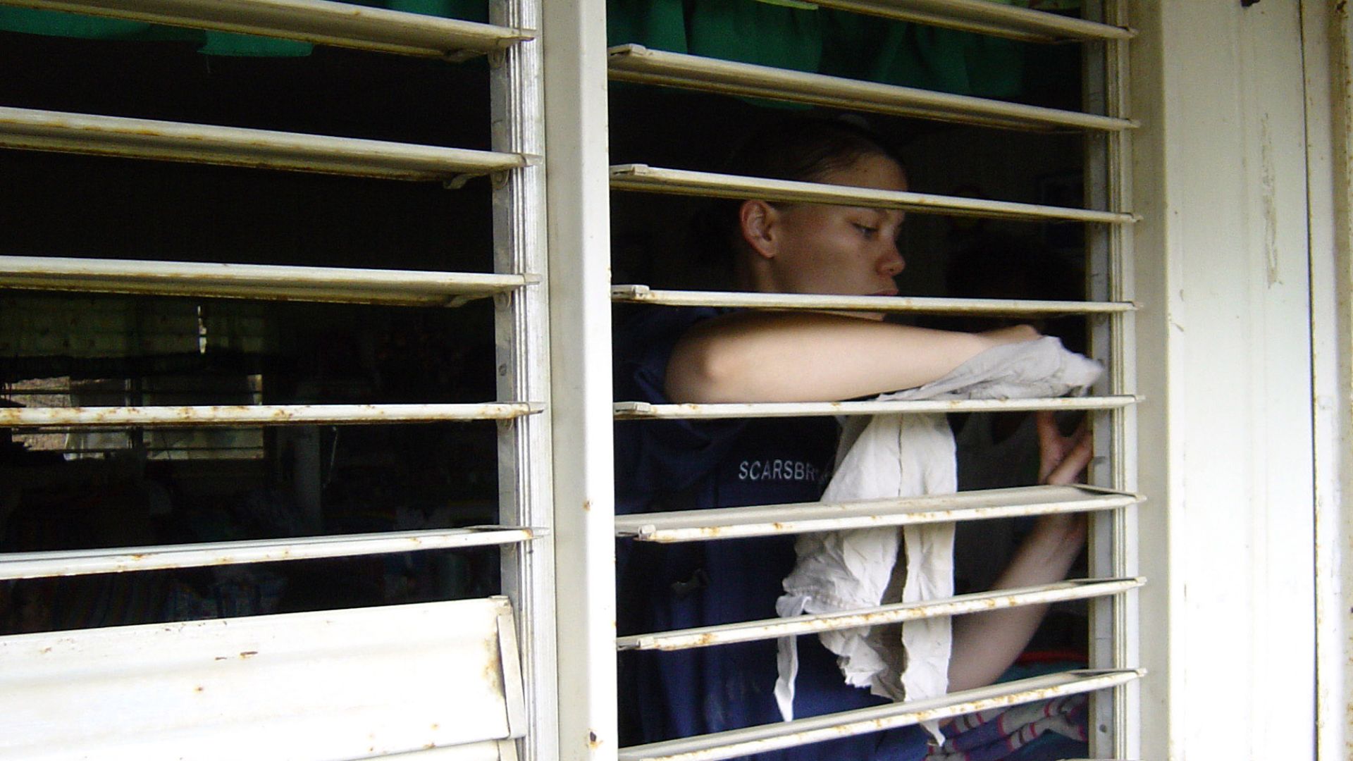 Saint Bernard, Philippines (Feb. 25, 2006) -
Quarter Master 3rd Class Carrie Scarsbrook, assigned to the amphibious dock landing ship USS Harpers Ferry (LSD 49), cleans window blinds of a classroom during a community service project at St. Bernard Element